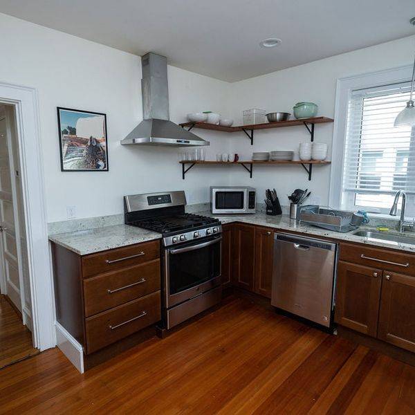 Kitchen with dark wood cabinets, stainless steel appliances and a window over the sink.