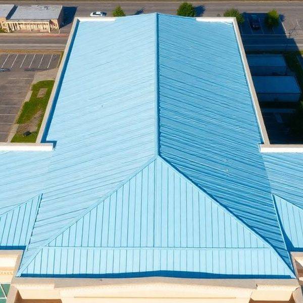 Aerial view of a light blue metal roof on a commercial building.