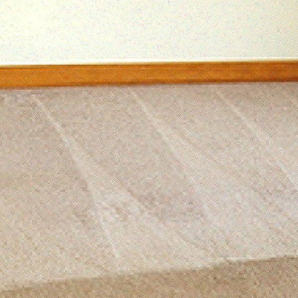 Beige carpet with a visible brush-stroke pattern beside a wooden baseboard.