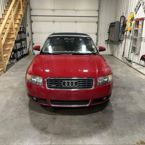 Red Audi convertible seen from the front, parked inside a garage.