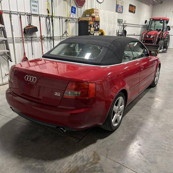 Red Audi convertible seen from behind, parked inside a garage.