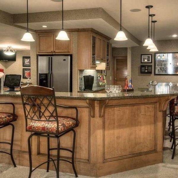 Basement bar with a wooden counter, tall stools and framed photos on the wall.