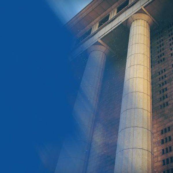 Tall columns of a court building against a blue sky