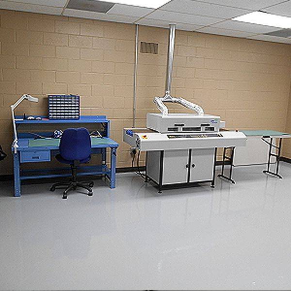 Assembly workstations with a bench, stool and equipment in a bright workroom.