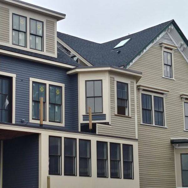 Blue-gray multi-story house with white trim and many windows.