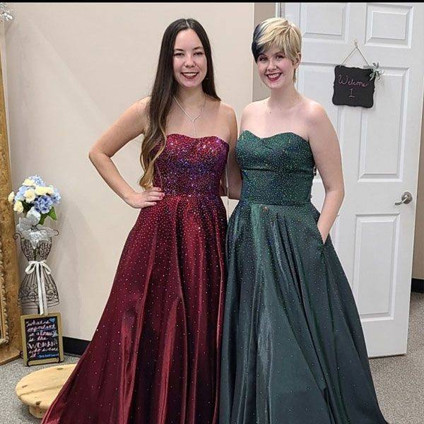 Two prom gowns, one burgundy and one dark green, with sweetheart necklines, displayed side by side.