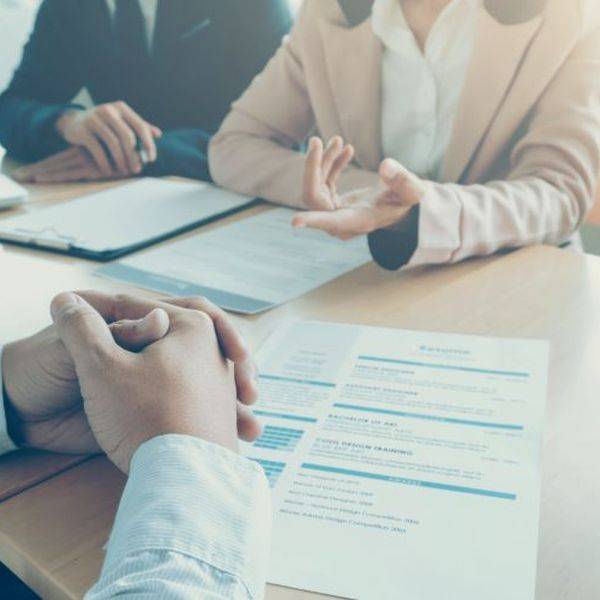 Hands clasped over paperwork during a business discussion at a table.