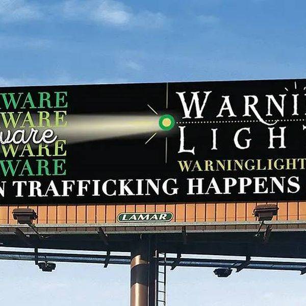 A roadside billboard warns people to be aware of human trafficking.